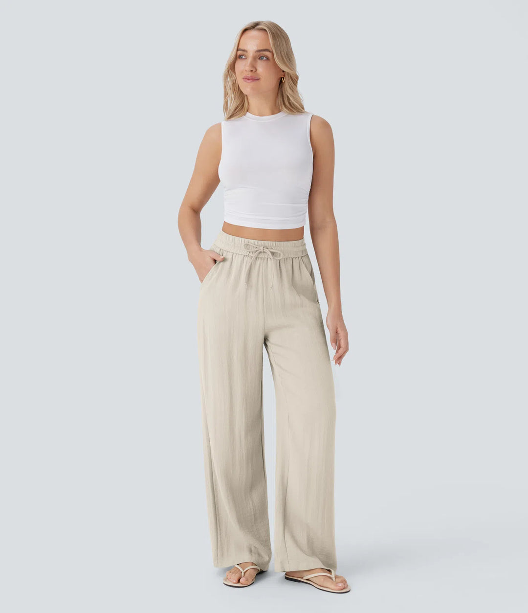 Pantalon décontracté taille haute, poches et cordon de serrage, jambes larges, aspect lin.