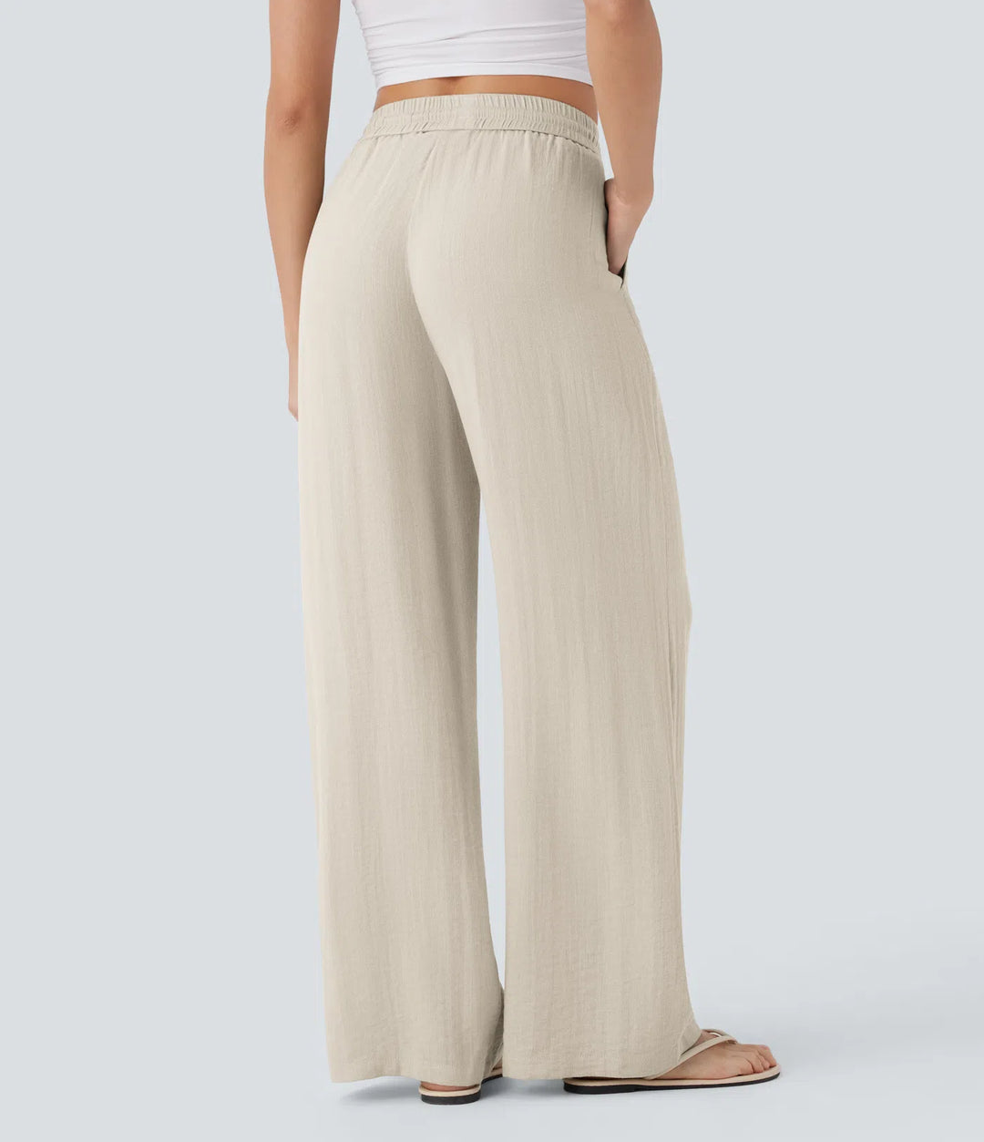 Pantalon décontracté taille haute, poches et cordon de serrage, jambes larges, aspect lin.