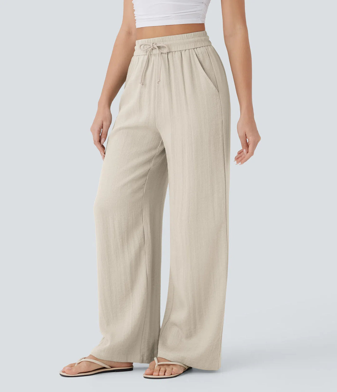 Pantalon décontracté taille haute, poches et cordon de serrage, jambes larges, aspect lin.