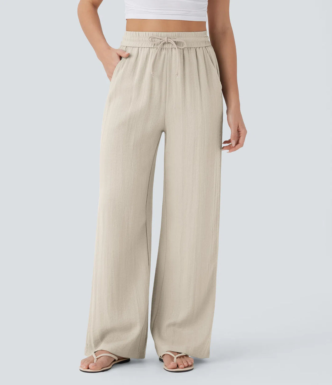 Pantalon décontracté taille haute, poches et cordon de serrage, jambes larges, aspect lin.